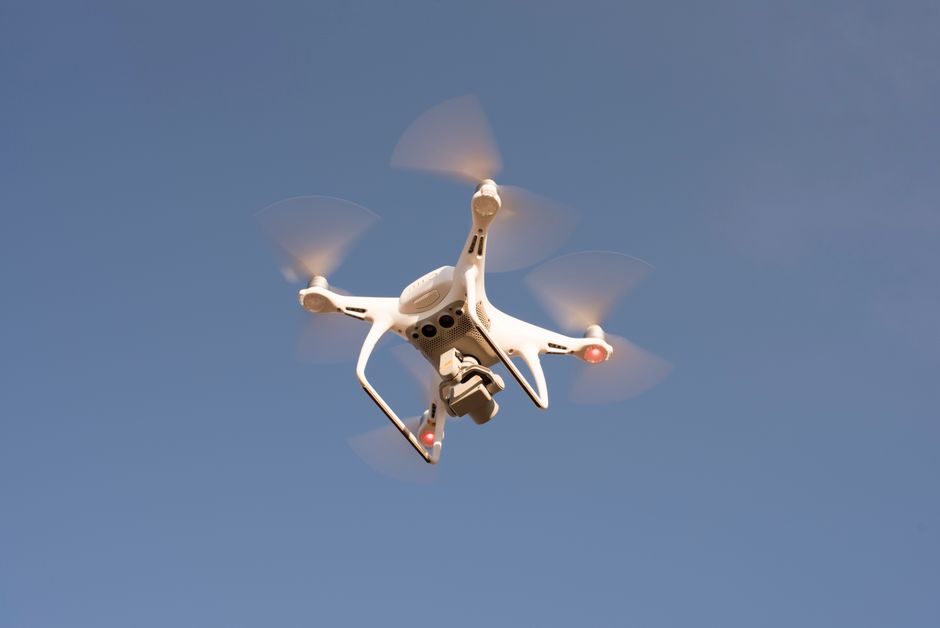 A drone flying over a facility, monitoring the perimeter for security and surveillance purposes, even in challenging weather conditions.